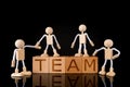 Teamwork concept, Wood cube block with word Ã¢â¬ÅTEAMÃ¢â¬Â and Wooden Stick Figures team.